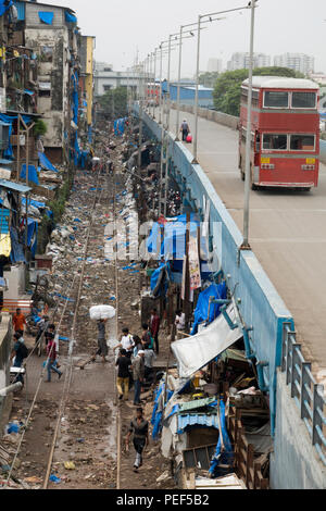 Double Decker Bus auf Station Road Neben Bahngleisen in Kunststoff Papierkorb wird in Bandra, Mumbai, Indien abgedeckt Stockfoto