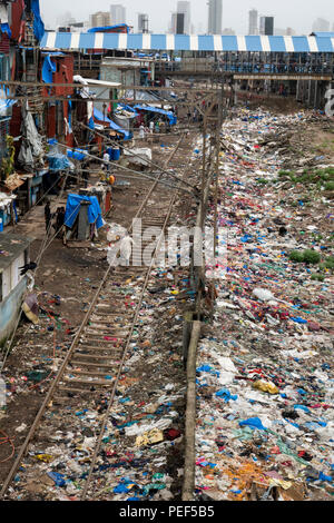 Stapel von Kunststoff Papierkorb neben dem Titel und slumgebiet in Bandra Bahnhof, Mumbai, Indien Stockfoto