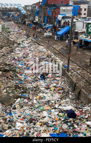 Stapel von Kunststoff Papierkorb neben dem Titel und slumgebiet in Bandra Bahnhof, Mumbai, Indien Stockfoto