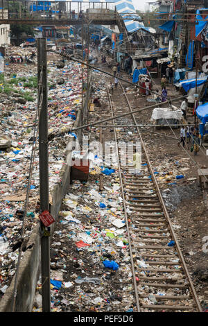 Stapel von Kunststoff Papierkorb neben dem Titel und slumgebiet in Bandra Bahnhof, Mumbai, Indien Stockfoto