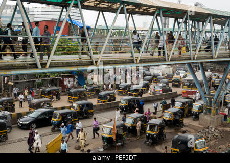 Auto-rikscha tuk tuks, die für die fahrgäste an Bandra Bahnhof mit Skywalk Fußgängerweg oben an der Station Road, Mumbai, Indien Stockfoto