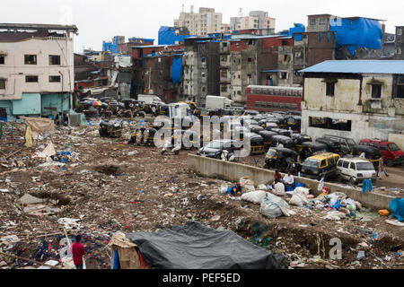 Slumgebiet in Papierkorb mit tuk tuk Auto-rikschas abgedeckt Warten auf Passagiere außerhalb von Bandra Bahnhof Skywalk in Mumbai, Indien Stockfoto