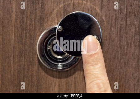 Eine weibliche Hand öffnet die Tür Guckloch Stockfoto