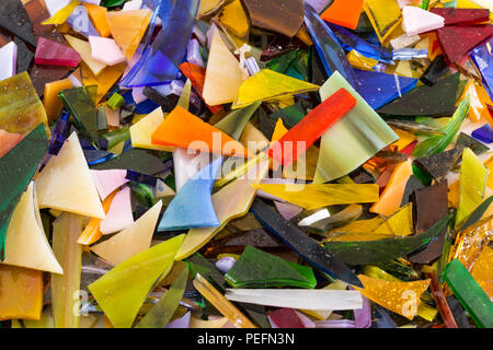 In der Nähe von hellen bunten Glasmalereien Chips in allen Formen und Größen verstreut und Überschneidungen in einer heiteren, glänzenden, einzigartigen, Spaß Hintergrund tex Stockfoto