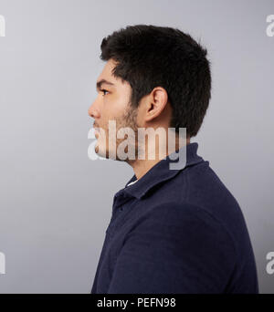 Junger Mann Profil anzeigen auf Grau studio Hintergrund isoliert Stockfoto