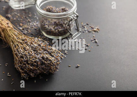 Kräuter Konzept. Getrocknetem lavendel Strauß auf schwarzen Hintergrund und in der Tischplatte Glas, kopieren. Stockfoto