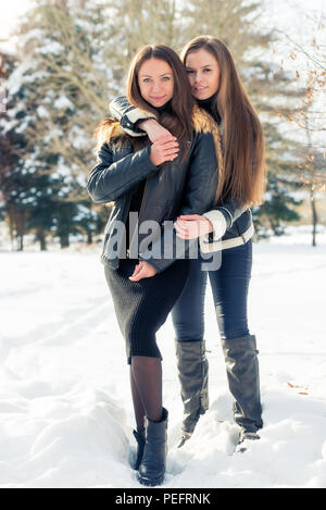 Umarmen den besten Freundinnen im Winter im Schnee Stockfoto