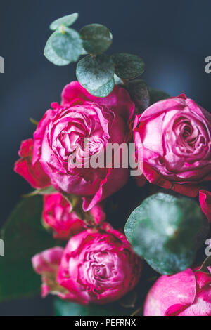 Makrofotografie von dunkel rosa Rosen Blumenstrauß über Blau. Soft Focus, Ansicht von oben, close-up Komposition. Stockfoto