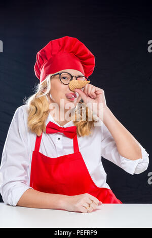 Frau Animator mit Waffel Cup für Speiseeis Grimassen auf schwarzem Hintergrund Stockfoto