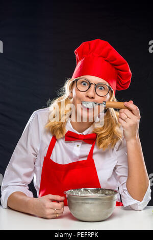 Porträt einer schönen Frau in einen Koch für Köche, Eis und versucht, es Stockfoto