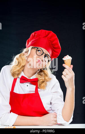 Nachdenkliches crazy Cook mit Sahne Eis in der Waffel cup Posing Stockfoto