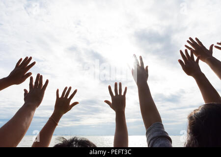 Viele Hände erhoben sich gegen den blauen Himmel. Freundschaft, Teamwork Konzept. Stockfoto