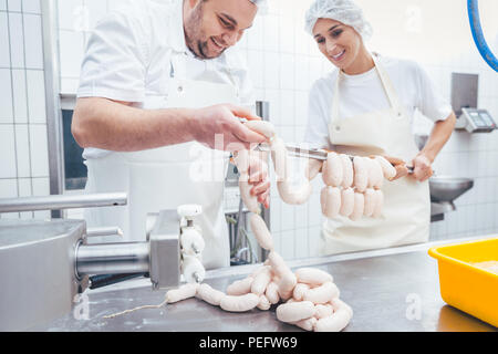 Team von Metzger Füllung Würstchen in der Fleisch verarbeitenden Industrie Stockfoto