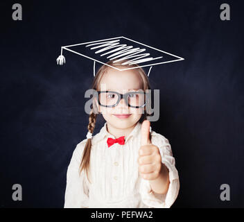 Schule Kind, Kind in Gläsern und Graduierung Hut auf Blackboard Hintergrund, Daumen hoch Stockfoto