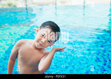 Cute asian kid Reinigung Ohren nach dem Schwimmen in einem Pool Stockfoto