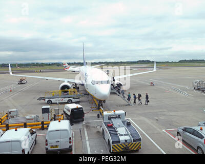 Zeigt alle im Flugzeug von vorne als Passagiere Treppen steigen, und auf der Flucht auf der Rollbahn am Flughafen Manchester, England Stockfoto