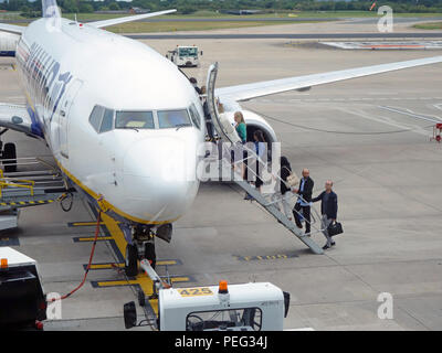 Passagiere klettern Schritte nach oben und auf der Flucht auf der Rollbahn am Flughafen Manchester, England Stockfoto