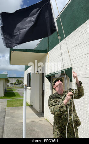 150820-N-SD 120-011 Okinawa, Japan (Aug. 20, 2015) Hospital Corpsman 1. Klasse Daniel Schnell wirft die schwarze Flagge nach der Temperatur am Naval Mobile Konstruktion Bataillon (NMCB) 5 Die medizinische Klinik auf Lager Schilde, Okinawa angehoben. Die schwarze Flagge warnt, dass die Temperatur erhöht hat und die Mitarbeiter sollten Vorsichtsmaßnahmen in Zusammenhang mit Wärmeentwicklung, um Verletzungen zu verhindern. NMCB 5 ist derzeit in Japan und einigen Ländern im Pazifischen Raum von Operationen Durchführung von Bauleistungen und humanitäre Hilfe Projekte bereitgestellt. (U.S. Marine Foto von Mass Communication Specialist 1. Klasse John S. Curtis/ Stockfoto