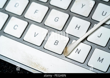 Dreckig Computer-tastaturen in Krankenhäusern verwendet, die ein erhebliches Risiko einer Infektion. Mit einem Wattestäbchen entfernen hartnäckige auf Schmutz auf die Leertaste. Stockfoto