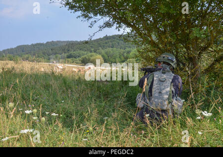 Ein US-Soldat der 1 Bataillon, 121 Infanterie Regiment, 48th Brigade Combat Team, Georgien Army National Guard, Replizieren ein feindlicher Kämpfer, Brände an britische Soldaten von Bravo Company, 1 Licht mechanisierten Bataillons, Royal Irish Regiment während der Durchführung einer Vorauszahlung Lane während der Übung Allied Spirit II bei der US Army Joint Multinational Readiness Center in Hohenfels, Deutschland, 12.08.13, 2015 in Verbindung zu setzen. Allied Spirit II ist eine multinationale entscheidende Maßnahmen Ausbildung Umwelt Übung, bei der mehr als 3.500 Soldaten aus den USA, Verbündete und Partner Nationen auf Gleichheit ausgerichtet Stockfoto