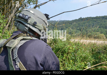 Ein US-Soldat der 1 Bataillon, 121 Infanterie Regiment, 48th Brigade Combat Team, Georgien Army National Guard, Replizieren ein feindlicher Kämpfer, Brände an britische Soldaten von Bravo Company, 1 Licht mechanisierten Bataillons, Royal Irish Regiment während der Durchführung einer Vorauszahlung Lane während der Übung Allied Spirit II bei der US Army Joint Multinational Readiness Center in Hohenfels, Deutschland, 12.08.13, 2015 in Verbindung zu setzen. Allied Spirit II ist eine multinationale entscheidende Maßnahmen Ausbildung Umwelt Übung, bei der mehr als 3.500 Soldaten aus den USA, Verbündete und Partner Nationen auf Gleichheit ausgerichtet Stockfoto