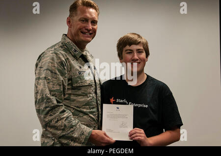 Colonel Blake Gettys, Kommandant der 176 Wing, Alaska Air National Guard, präsentiert Brice Wilbanks, Sohn von Oberst Patty Wilbanks, Kommandant der 176. Mission Support Group, die mit einem Buchstaben von Generalleutnant Stanley Clarke III, Direktor der Air National Guard, bei einer Zeremonie auf einer gemeinsamen Basis Elmendorf-Richardson, Alaska, 12.08.14. Brice wurde der Brief in der Anerkennung, dass der Empfänger der 2015 Air National Guard Jugend des Jahres ausgezeichnet. (U.S. Air National Guard Foto: Staff Sgt. Edward Eagerton/freigegeben) Stockfoto