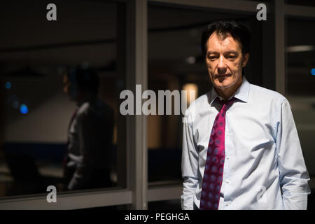 Portrait von betonte Reife Geschäftsmann in Büro in der Nacht Stockfoto