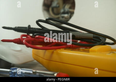 Werkzeuge für die Verkabelung einer elektrischen Steckdose auf dem Boden neben der Kunststoffabdeckung und freien Sockel zeigt interne Schaltkreise Stockfoto