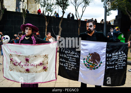 Mexiko-Stadt, Mexiko,; 1. November 2015: Eine Frau mit ayotzinapa-flagge und ein Mann mit mexikanischer schwarzer Flagge am Tag der Totenfeier in Mexiko-Stadt Stockfoto