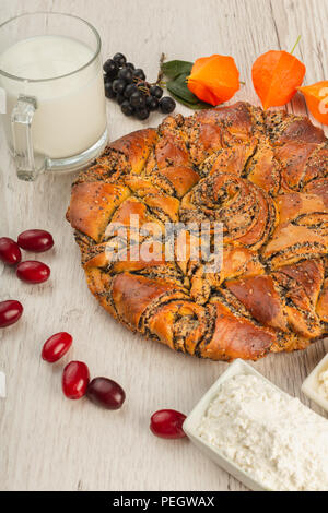 Kuchen mit Mohn auf einer hölzernen Hintergrund und Zutaten. Stockfoto