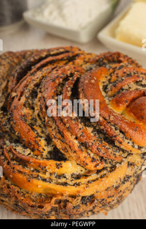 Kuchen mit Mohn auf einer hölzernen Hintergrund und Zutaten. Stockfoto