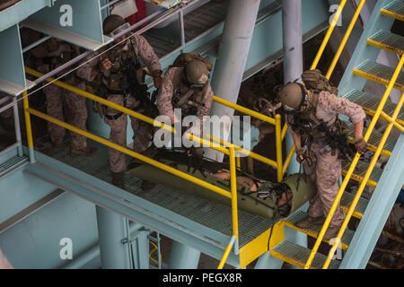 Marines von Kompanie C, 1. Aufklärungsbataillon, 1. Marine Division, 13. MEU führen eine simulierte Evakuierung von Unfällen an Bord einer Gas- und Ölplattform in Carpentaria, Kalifornien, am 21. August 2015 durch. Die Übung trainiert Marines in medizinischen Evakuierungstechniken, der Handhabung von Patienten, der schnellen Extraktion, der Teamkoordination und der operativen Verfahren für maritime Notfälle, um die Bereitschaft und Sicherheit bei Offshore-Missionen zu gewährleisten. Stockfoto