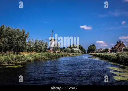 Landschaft Blick auf die Mühle von Hoeke, in der Stadt Damme in der Nähe von Brügge im Norden Belgiens, mit bewölktem Himmel im Hintergrund Stockfoto