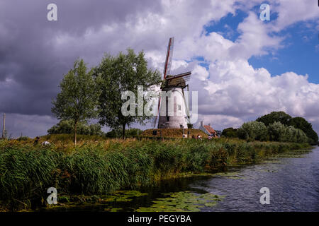 Landschaft Blick auf die Mühle von Hoeke, in der Stadt Damme in der Nähe von Brügge im Norden Belgiens, mit bewölktem Himmel im Hintergrund Stockfoto