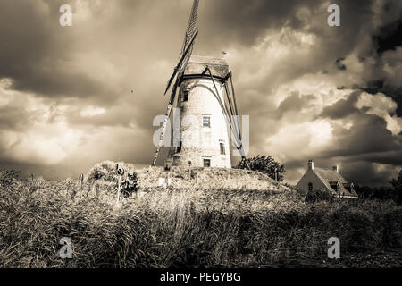 Landschaft Blick auf die Mühle von Hoeke, in der Stadt Damme in der Nähe von Brügge im Norden Belgiens, mit bewölktem Himmel im Hintergrund Stockfoto