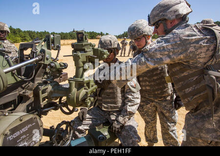 Staff Sgt. Bryan Junge, rechts, und Sgt. Santiago Sanchez, links, 2. Lt. Jennifer Wain, alle mit der 3-112 th Field Artillery, New Jersey Army National Guard, die Sichtung System auf die digitale M119A3 105mm leichte Haubitze während einer Live Fire Übung in Joint Base Mc Guire-Dix - Lakehurst, New Jersey, 26.08.2015. Wain, ein Feuer Richtung Offizier mit der 3-112., ist die erste weibliche Combat Arms Officer in der Geschichte der New Jersey Army National Guard. Der M 119 A3 mit einem digitalen Brand Control System mit einem inertialen Navigationssystem ausgerüstet ist, geführte - Precision System t Stockfoto