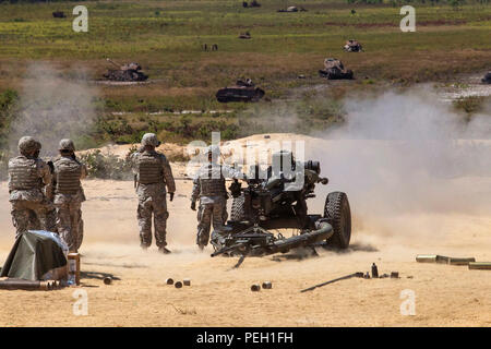 Soldaten, die in den Th 3-112 Field Artillery, New Jersey Army National Guard, zusehen, wie 2. Lt. Jennifer Wain die digitale M119A3 105mm leichte Haubitze während einer Live Fire Übung in Joint Base Mc Guire-Dix - Lakehurst, New Jersey, 12.08.26, 2015 Feuer. Wain, ein Feuer Richtung Offizier mit der 3-112., ist die erste weibliche Combat Arms Officer in der Geschichte der New Jersey Army National Guard. Der M 119 A3 mit einem digitalen Brand Control System mit einem inertialen Navigationssystem ausgerüstet ist, geführte - Precision System Technologie und andere Funktionen, die die Waffe die Fähigkeit, det geben Stockfoto