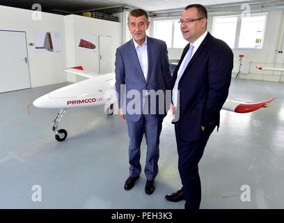 Radotin, Tschechische Republik. 14 Aug, 2018. Der tschechische Premierminister Andrej Babis (links) Tschechische unbemannte Luftfahrzeuge (UAVs) für die Grenzkontrollen wird als Hilfe Grenzen gegen illegale Migration in Italien und Malta während seiner Reise in diese Länder in zwei Wochen zum Schutz bieten, Babis sagte vor Journalisten bei seinem Besuch der Primoco Produktionsanlage in Radotin, in der Nähe von Prag, Tschechische Republik, am 14. August 2018. Auf dem Hintergrund des Fotos ist ein Primoco UAV Unmanned Aerial Vehicle gesehen, auf der rechten Seite steht der CEO von Primoco Ladislav Semetkovsky. Credit: Roman Vondrous/CTK Photo/Alamy leben Nachrichten Stockfoto
