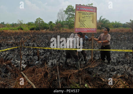 Pekanbaru, RIAU, Indonesien. 15 Aug, 2018. Polizei versiegelt die brennende Torfgebiete für eine Untersuchung in Kampar Bezirk, Provinz Riau, Indonesien nach Indonesien der Meteorologie, Klimatologie und Geophysik (BMKG), Hotspots wurden auch in anderen Provinzen auf Sumatra beobachtet wie in Lampung 1 Hotspot, in Nordsumatra 14 Hotspots, in West Sumatra 13 Hotspots und 2 Hotspots in Süd-sumatra. Moore Brände, die auf Sumatra aufgrund der trockenen Jahreszeit aufgetreten. Credit: ZUMA Press, Inc./Alamy leben Nachrichten Stockfoto