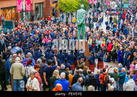 Glasgow, UK. 15. Aug 2018. Straßentheater in der Buchanan Street, Glasgow mit mehr internationale Pipe Bands spielen in der Nähe der Donald Dewar Statue die Öffentlichkeit für sich zu unterhalten. Die Pipe Band Championships schließen am Samstag, den 18. August auf Glasgow Green. Mitglieder der Simon Fraser University Pipe Band aus British Columbia, Kanada Kredit: Findlay/Alamy leben Nachrichten Stockfoto