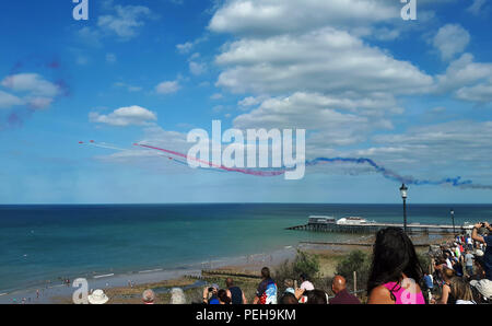 Cromer, Norfolk, Großbritannien. 15. Aug 2018. Die Menschen genießen die Royal Air Force Red Arrows display Team als führen ihre Show im Cromer Karneval, Cromer, Norfolk, am 15. August 2018. Credit: Paul Marriott/Alamy leben Nachrichten Stockfoto