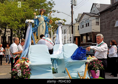 Cleveland, Ohio, USA. 15 Aug, 2018. Männer setzen In die Statue der Jungfrau Maria, die sie gerade aus der Heilige Rosenkranz Kirche in Cleveland, Ohio. Die Statue ist ein Teil der Prozession, die den Anfang des 120. jährliche Fest der Himmelfahrt in Cleveland's Little Italy Nachbarschaft Mark. Sobald Sie fertig sind, mit denen die Statue, wird es um die Nachbarschaft zusammen mit den Teilnehmern, ihre italienischen Erbe feiern vorgeführt werden. Credit: Mark Kanning/Alamy leben Nachrichten Stockfoto