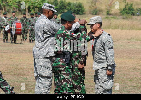 Brig. Gen. Gary Brito, stellvertretender Kommandierender General, 25 Infanterie Division und Brig. Gen. Agus Suhardi, Stabschef, 1 Kostad Infanterie Division, Tentara Nasional Indonesia Armee, Schlüsselbänder auf zwei Soldaten signalisiert den Beginn des Garuda Shield 2015 während der Eröffnungsfeier in Cibenda, Indonesien, am 12.08.20., 2015. Stockfoto