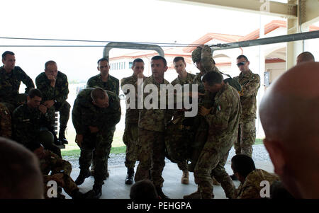 Eine italienische Armee jumpmaster der 186th Folgore Parachute Regiment zugeordnet gibt Anweisungen, wie die US-T-11 Fallschirm zu italienischen, amerikanischen und bulgarischen Fallschirmjäger 23.08.2015, an der Airbase Aviano, Italien, in der Vorbereitung für einen kombinierten Sprung mit 173Rd Airborne Brigade der US-Armee in Bulgarien für die schnelle Antwort 15. Schnelle Reaktion ist ein groß angelegtes kombiniert, gemeinsame Übung mit 4.500 Soldaten aus 12 NATO-Staaten, mit Airborne operations, verteilt auf drei Länder. (U.S. Armee Foto: Staff Sgt. Opal Vaughn) Stockfoto