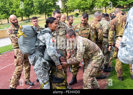 Kapitän Lucretia Glaspie, ein jumpmaster und eine Firma Commander mit Delta Truppe, 3.Staffel, 73 Kavallerie Regiments, 1st Brigade Combat Team, 82nd Airborne Division hält eine Italienische Rucksack als Kapitän Francesco Vastante, ein Offizier mit dem Training und der Operationen Zweig der Folgore Airborne Brigade Headquarters Clips zu Ihren Fallschirm Kabelbaum Ausrüstung Ringe am 22. August 2015 bei Smith Kaserne in Baumholder, Deutschland. Fallschirmjäger aus sechs NATO-Staaten - Deutschland, Niederlande, Polen, Vereinigtes Königreich, Italien und Spanien - Verband der 'DÜbel in sackartigen Hosen" der 504th Parachute Infantry Regime Stockfoto