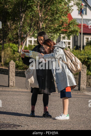 Touristen, die auf der Suche auf Karte, Reykjavik, Island Stockfoto