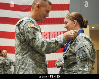 New York Army National Guard Major General Patrick Murphy, der Adjutant General von New York, präsentiert das New York State-Medaille für Valor, höchste militärische Auszeichnung des Staates, an das Personal Sgt. Marlana Watson, ein Bewohner von Lindenhurst, N.Y., am 12.08.19, 2015 in Farmingdale, New York, Streitkräfte finden. Watson, ein Mitglied der Rekrutierung der New York Army National Guard und Retention Bataillon und ein Medic, war für das Hetzen in Syrakus Straße an November 5, 2014 anerkannt, zwei Teenager in einem Verletzten zu behandeln - durch das Schießen, ohne Rücksicht auf ihre eigene Sicherheit, denn der Shooter haben können Stockfoto