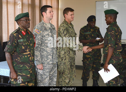 Die Beseitigung von Explosivstoffen Techniker 1. Klasse Ben Schwegler, gratuliert Pvt. Ramadhan Badru Mwita, Tansanias Menschen Defence Force Munition Techniker, während der humanitären Minenräumung den erfolgreichen Abschluss des Kurses am Peacekeeping Training Center in Dar-es-Salaam, Tansania, Nov. 27, 2015. Schwegler, kombiniert zu Joint Task Force - Horn von Afrika zugeordnet, beauftragte den HMA Kurs für TPDF Studenten um den Partner nation Ordnance Knowledge zu erhöhen. Stockfoto