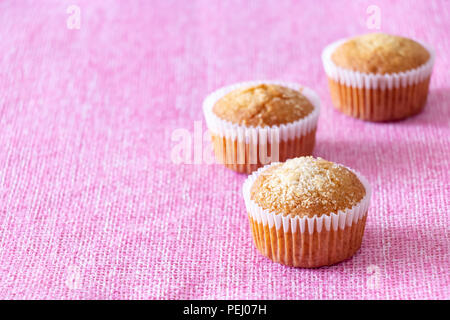Hausgemachte vanille Muffins mit Kokosnuss Pulver. Rosa Hintergrund. Kopieren Sie Platz. Selektive fcus. Stockfoto