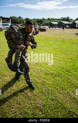 Einen honduranischen Feuerwehrmann trägt eine andere Marine während des Manövers unter Feuer Teil der Bekämpfung der Fitness Test am Marinestützpunkt Puerto Castilla, Honduras, 12.08.2015. Us-Marines mit Sicherheit Zusammenarbeit Team-Honduras, Special Purpose Marine Air-Ground Task Force-Southern Befehl das Ereignis überwacht. SCT-Honduras ist derzeit als Teil der SPMAGTF-SC bereitgestellt werden, um das Centro de Adiestramiento Naval mit der Umsetzung eines Lehrplans einen Honduranischen marine Programm zu schaffen, zu unterstützen. (U.S. Marine Corps Foto von Cpl. Katelyn Hunter/Freigegeben). Stockfoto